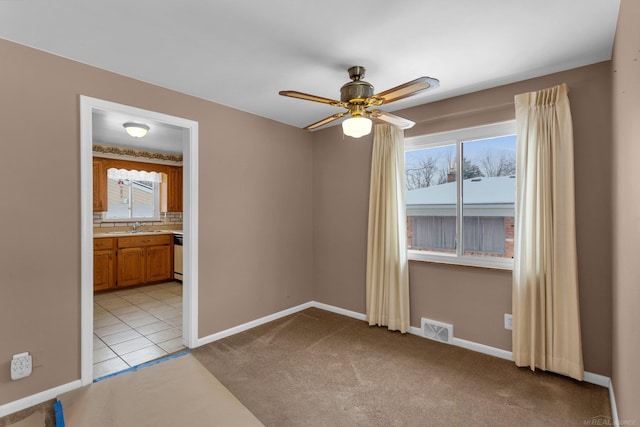 carpeted empty room featuring ceiling fan and sink