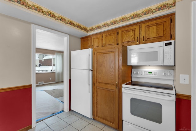 kitchen featuring light tile patterned floors and white appliances