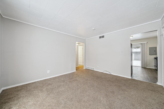 spare room with carpet flooring, ornamental molding, and electric panel