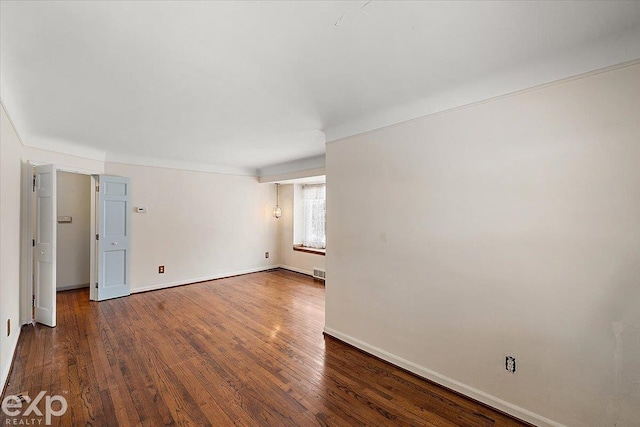 empty room with dark hardwood / wood-style flooring