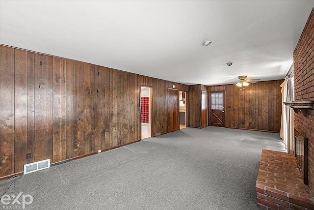 unfurnished living room featuring carpet floors, ceiling fan, and a fireplace