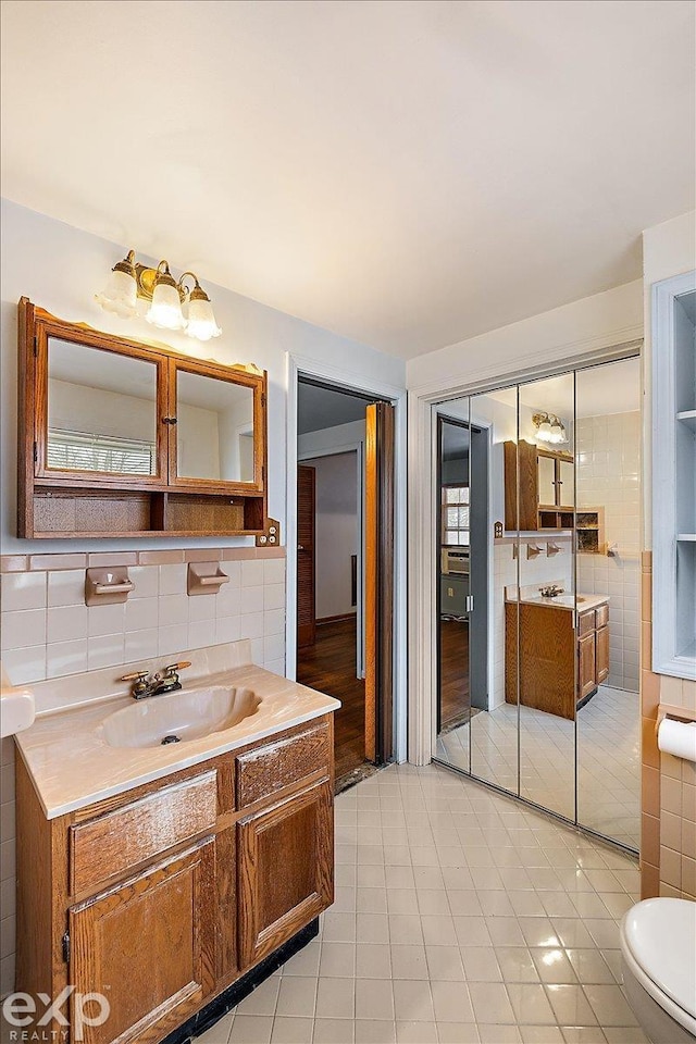 bathroom featuring tile walls, tile patterned floors, and vanity