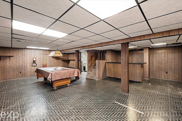 game room featuring a drop ceiling, pool table, and wood walls