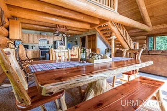 unfurnished dining area featuring rustic walls, wood ceiling, and vaulted ceiling with beams