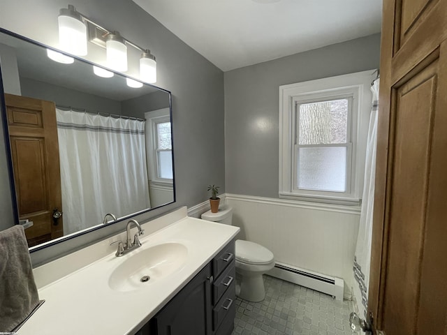 bathroom featuring a baseboard heating unit, toilet, and vanity