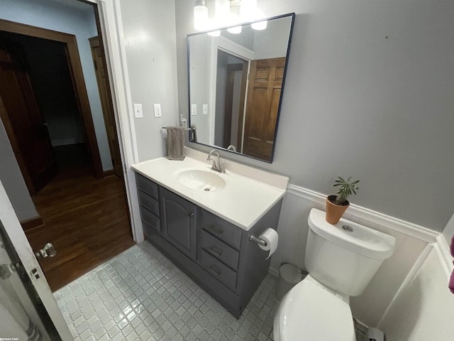 bathroom with toilet, vanity, and tile patterned floors