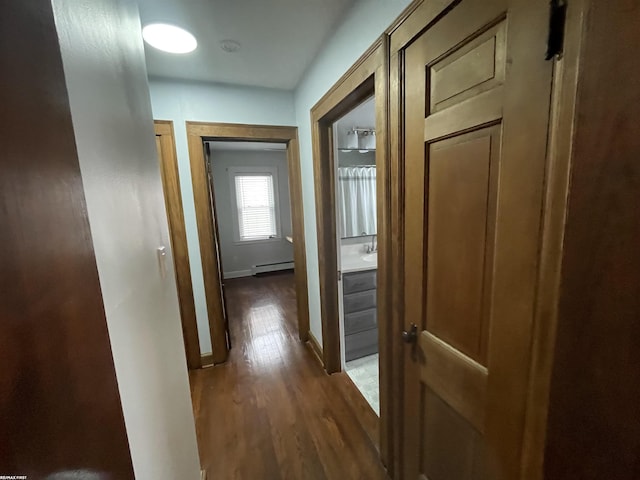 hallway featuring baseboard heating and dark hardwood / wood-style flooring