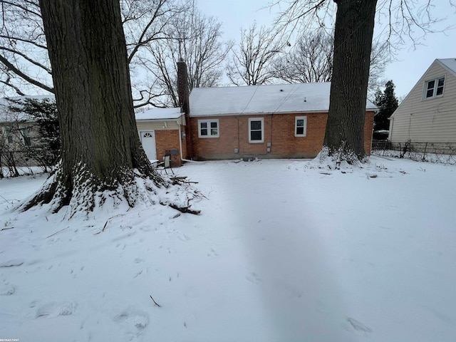 view of snow covered back of property