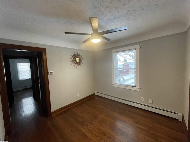 unfurnished room featuring ceiling fan, a baseboard heating unit, dark wood-type flooring, and a textured ceiling