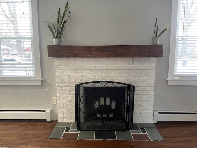 room details featuring a fireplace, wood-type flooring, and a baseboard radiator