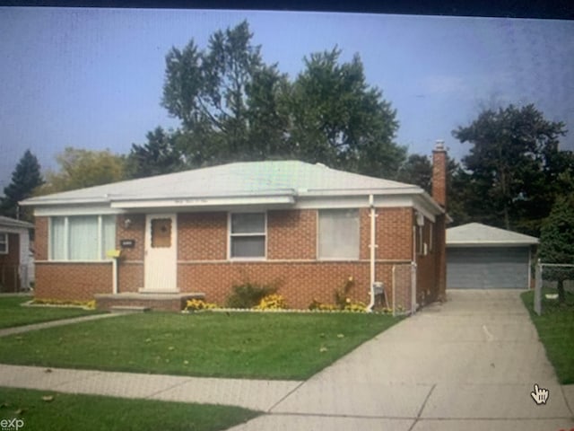 view of front of home featuring a garage, a front lawn, and an outdoor structure