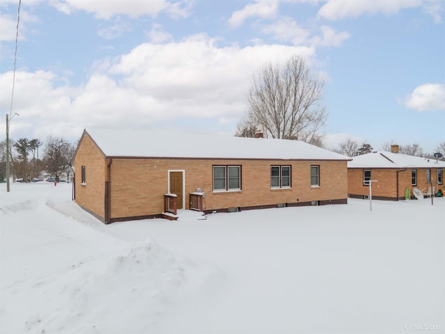 view of snow covered back of property