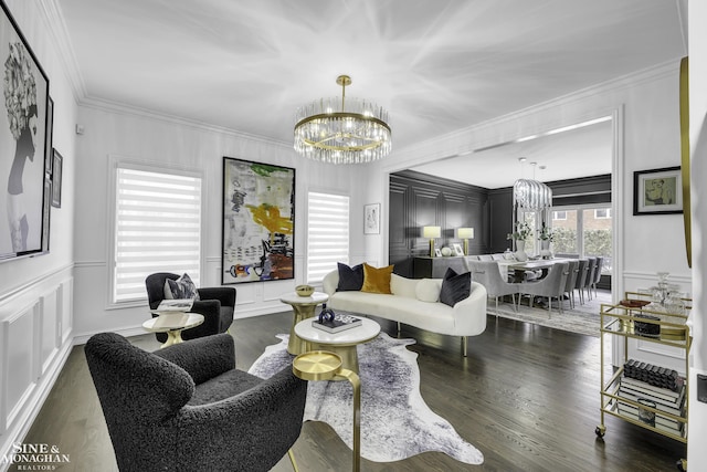 living room with dark hardwood / wood-style floors, ornamental molding, and a notable chandelier