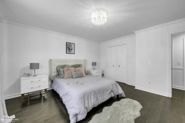 bedroom with a closet, dark wood-type flooring, ornamental molding, and a notable chandelier