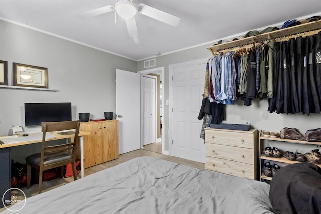 bedroom with ceiling fan, wood-type flooring, a closet, and crown molding