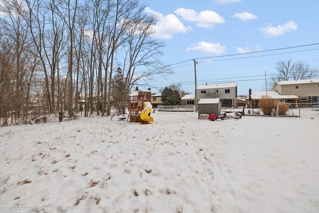 yard covered in snow with a playground