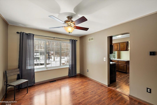 spare room featuring hardwood / wood-style flooring, ornamental molding, and ceiling fan