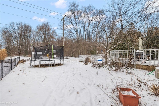 snowy yard with a trampoline