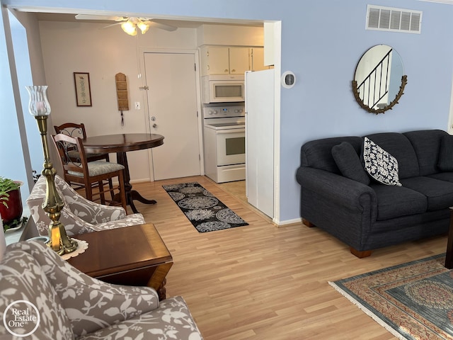 living room featuring ceiling fan and light hardwood / wood-style flooring