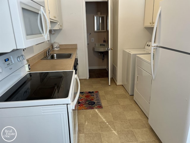 kitchen featuring sink, washer and clothes dryer, white cabinets, and white appliances