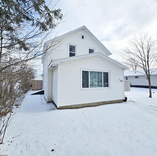 view of snow covered back of property