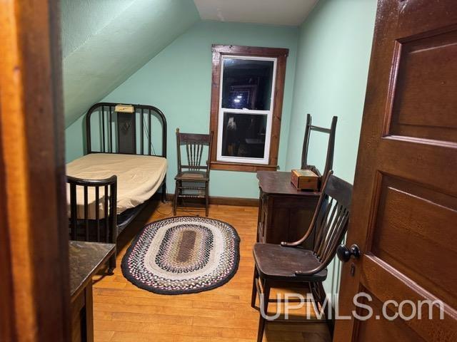 bedroom featuring vaulted ceiling and wood-type flooring