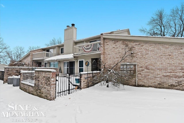 snow covered property with a balcony