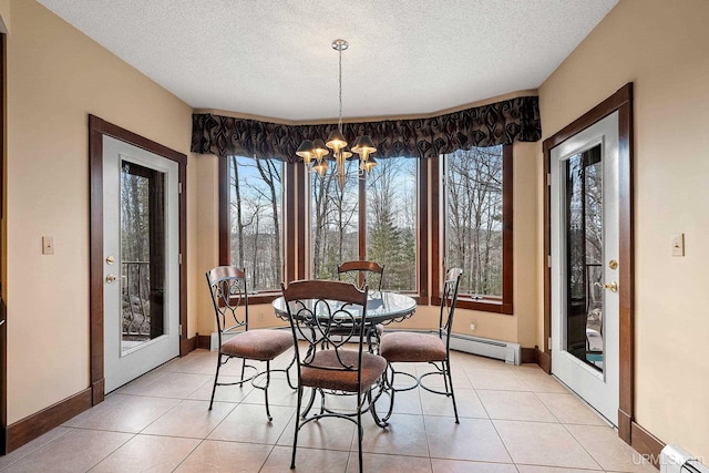 tiled dining space with a textured ceiling, a notable chandelier, and a baseboard radiator