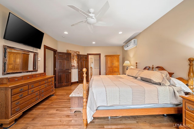 bedroom featuring a wall unit AC, ceiling fan, and light hardwood / wood-style floors