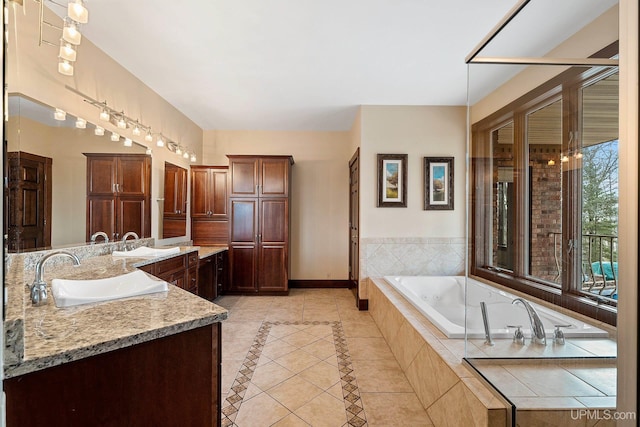 bathroom featuring tiled tub, tile patterned floors, and vanity