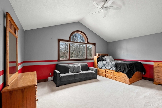 bedroom featuring a textured ceiling, a baseboard heating unit, light carpet, vaulted ceiling, and ceiling fan