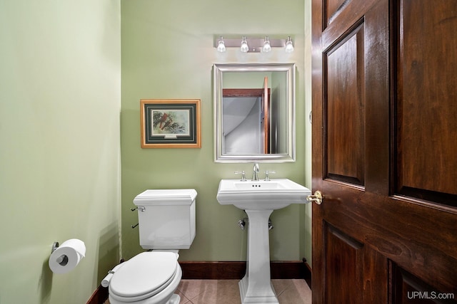 bathroom featuring toilet, tile patterned flooring, and sink