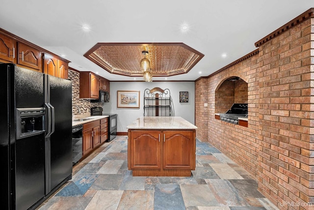 kitchen with a center island, black appliances, decorative backsplash, crown molding, and brick wall