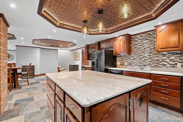 kitchen with a center island, ornamental molding, and black fridge with ice dispenser