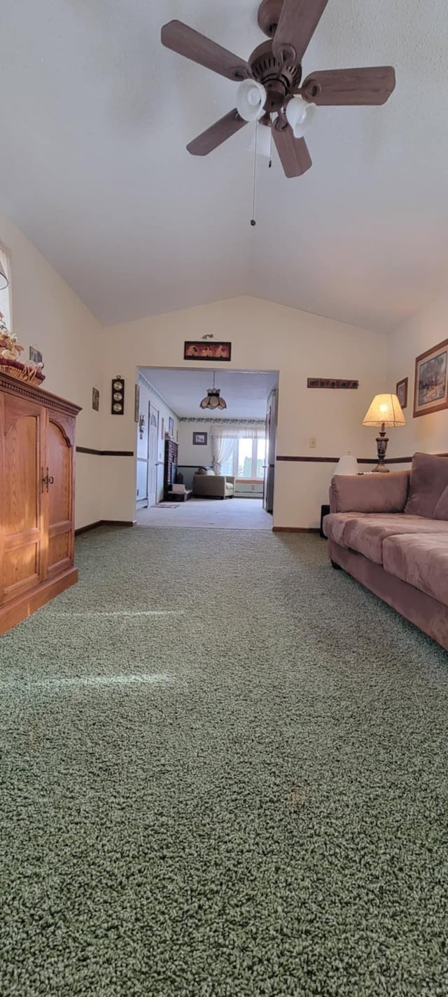 unfurnished living room featuring ceiling fan, lofted ceiling, and carpet floors