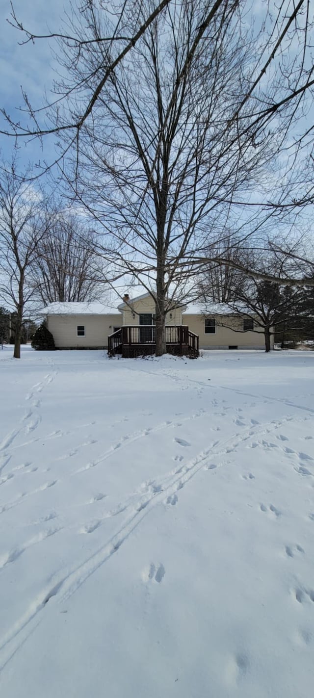 yard layered in snow featuring a wooden deck