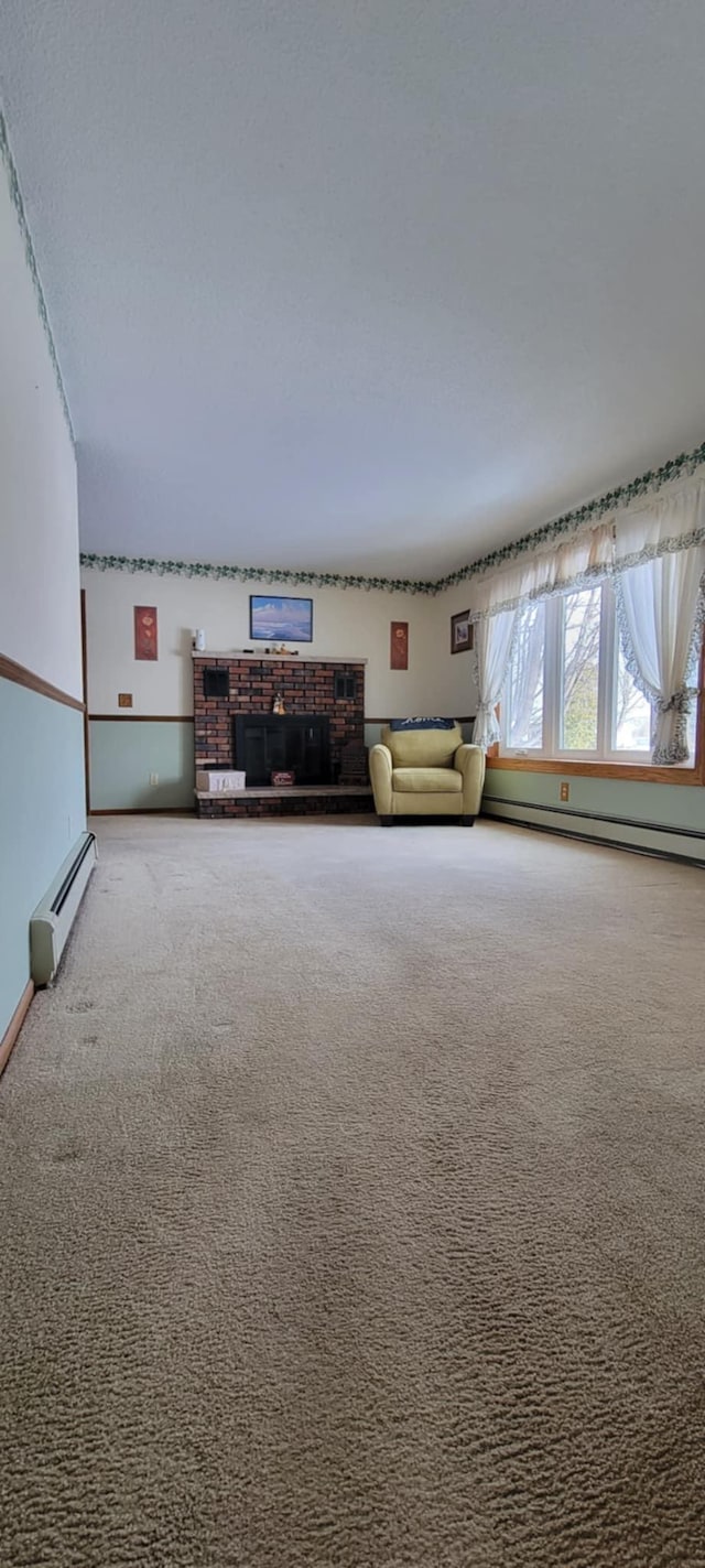 unfurnished living room featuring baseboard heating and carpet flooring