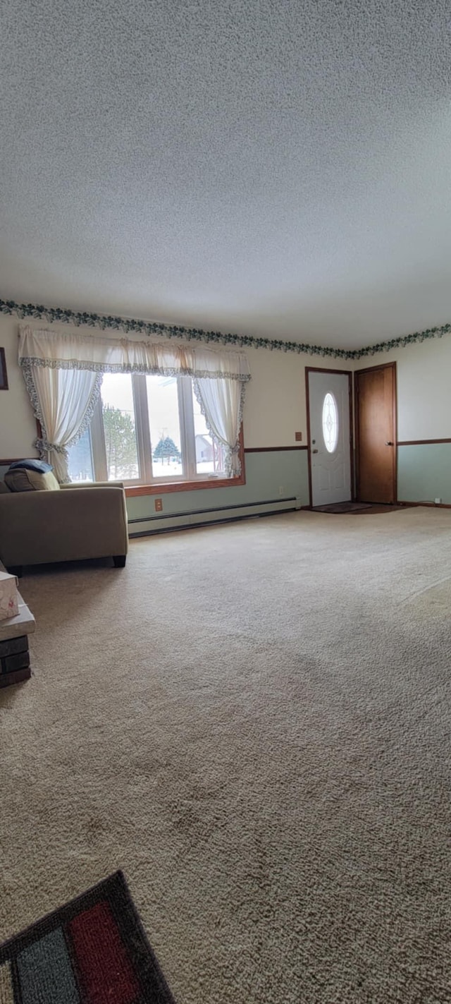 unfurnished living room featuring a baseboard radiator, carpet, and a textured ceiling