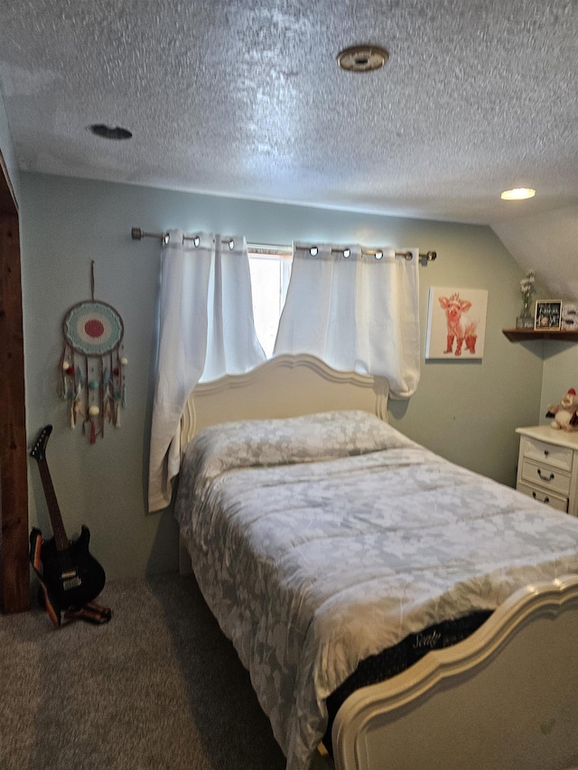 carpeted bedroom with a textured ceiling and vaulted ceiling