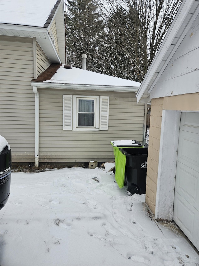 view of snow covered exterior with a garage