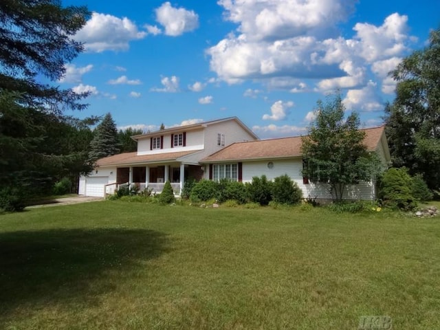 back of property featuring a garage, a lawn, and covered porch