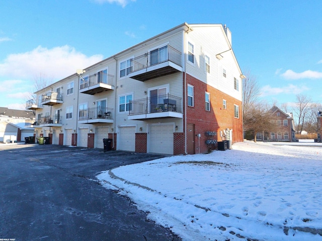 snow covered building featuring central AC unit