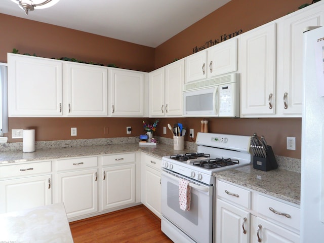 kitchen featuring white appliances, white cabinets, and light hardwood / wood-style flooring