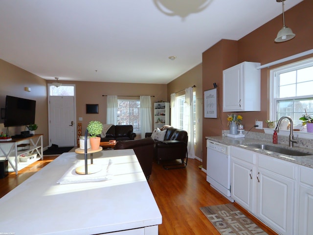 kitchen featuring white cabinetry, white dishwasher, hanging light fixtures, and sink