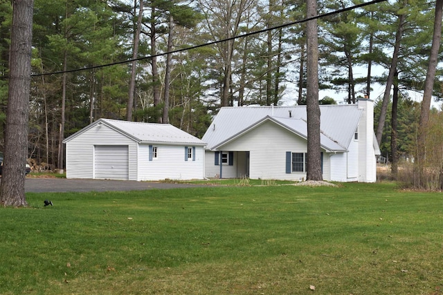 view of front of house with an outbuilding, a garage, and a front yard