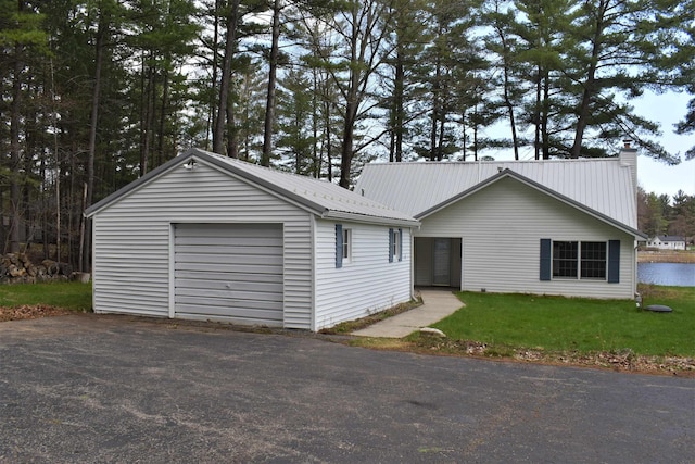 ranch-style home featuring an outbuilding, a front yard, and a garage