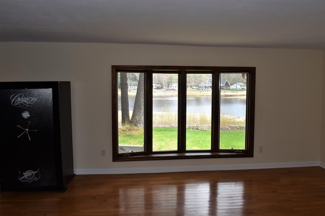 spare room with a water view and hardwood / wood-style flooring