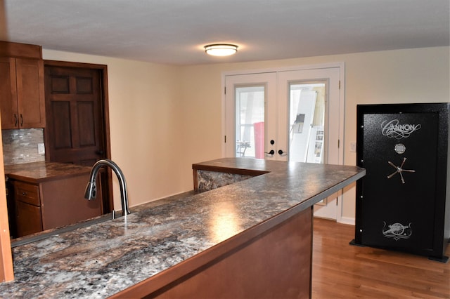 kitchen featuring backsplash, french doors, and light wood-type flooring