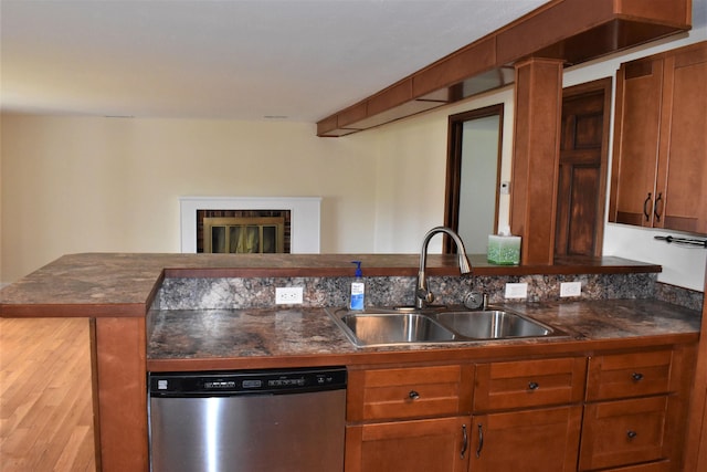 kitchen featuring stainless steel dishwasher, kitchen peninsula, and sink