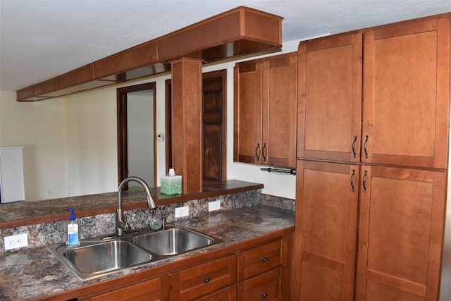 kitchen featuring sink and dark stone countertops